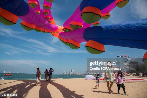 Tourists seen walking near a giant squid kite on the Pattaya beach during the festival. The Pattaya Fireworks Festival is scheduled for November...