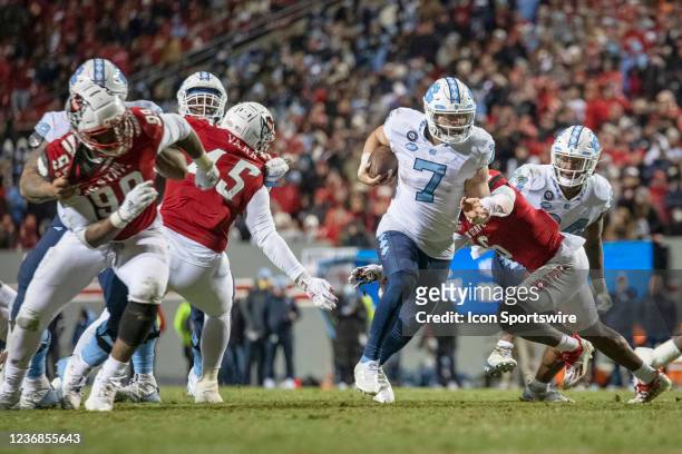 North Carolina Tar Heels quarterback Sam Howell breaks a tackle by North Carolina State Wolfpack safety Jakeen Harris during the NCAA football game...