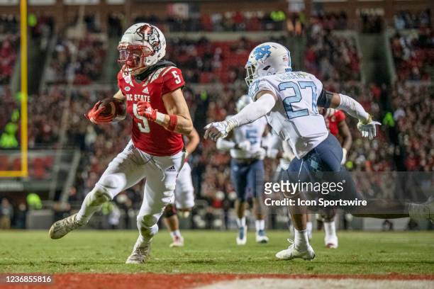 North Carolina State Wolfpack wide receiver Thayer Thomas scores a touchdown as he runs by North Carolina Tar Heels defensive back Giovanni Biggers...