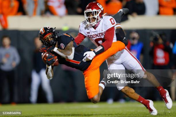 Wide receiver Tay Martin of the Oklahoma State Cowboys brings down the ball off a pass in the end zone against cornerback Woodi Washington of the...