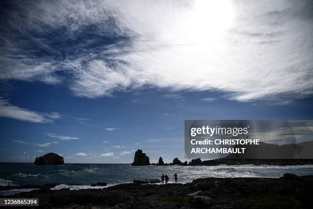 Tourists stand on a beach at the Anse des Chateaux, in Saint-Francois on the eastern edge of the French Caribbean island of Guadeloupe on November...