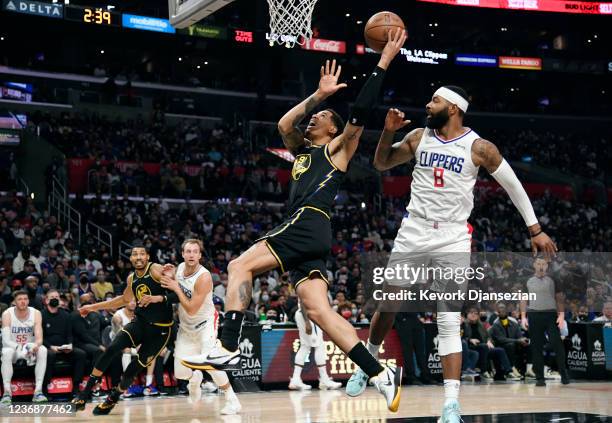 Juan Toscano-Anderson of the Golden State Warriors drives and scores a basket against Marcus Morris Sr. #8 of the Los Angeles Clippers in the second...