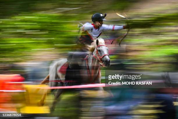 This picture taken on November 13, 2021 shows a participant taking part in a Horseback Archery League competition at Cape Cavallho Equestrian Club in...