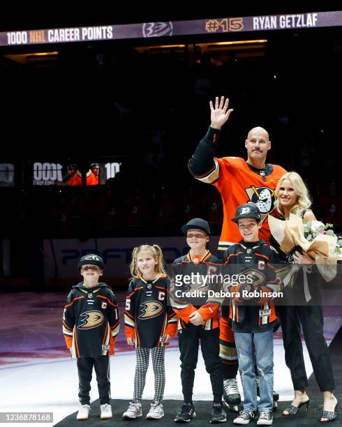 Ryan Getzlaf of the Anaheim Ducks waves to fans with his wife Paige Getzlaf and children to honor Ryan Getzlaf reaching 1000 NHL career point prior...