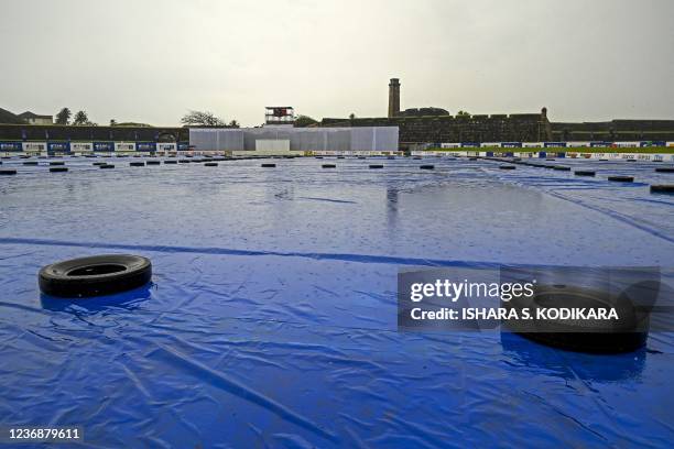 General view shows the field covered as it rains before the start of the first day play of the second Test cricket match between Sri Lanka and West...