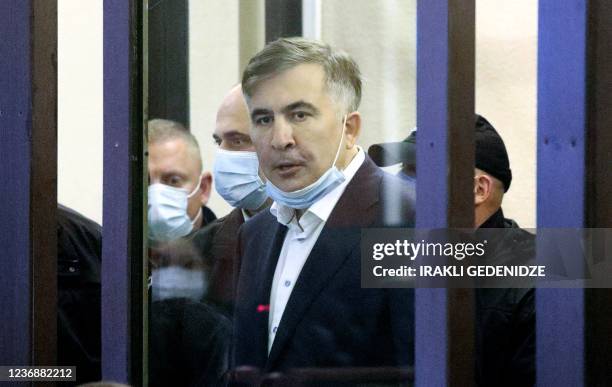 Georgia's jailed opposition leader and ex-president Mikheil Saakashvili arrives in the defendant's box for an earing at the city court of Tbilisi on...