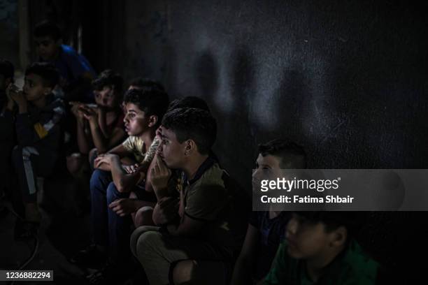 Palestinian children attend a movie screening in the street in Jabalia refugee camp on November 7 2021 in Gaza City, Gaza. Gaza's first cinema was...