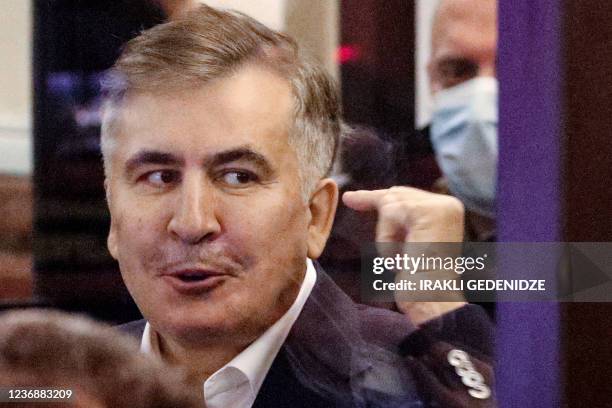 Georgia's jailed opposition leader and ex-president Mikheil Saakashvili gestures from the defendant's box during an earing at the city court of...