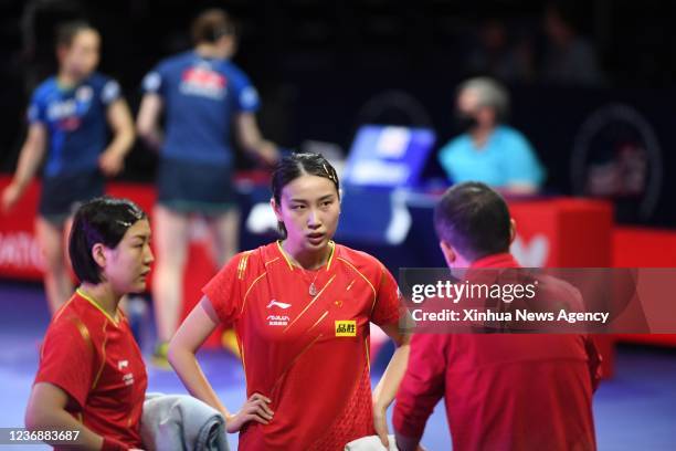 China's Chen Meng front L/Qian Tianyi front C listen to the coach Ma Lin during the women's doubles semifinal match against Japan's Ito Mima/Hayata...