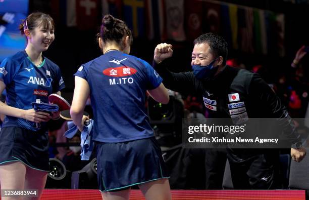 Japan's Ito Mima C/Hayata Hina celebrate with their coach during the women's doubles semifinal match against China's Chen Meng/Qian Tianyi at 2021...