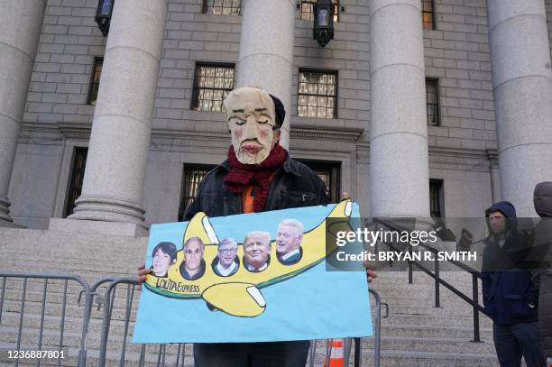 Man holds a sign outside the Thurgood Marshall United States Courthouse as the trial of Ghislaine Maxwell begins in New York on November 29, 2021. -...