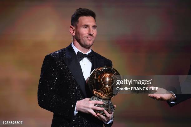 Paris Saint-Germain's Argentine forward Lionel Messi poses after being awarded the the Ballon d'Or award during the 2021 Ballon d'Or France Football...
