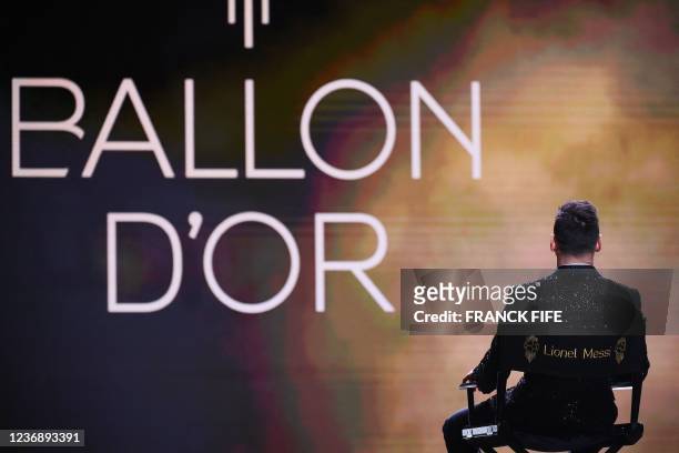 Paris Saint-Germain's Argentine forward Lionel Messi watches a film in his honour after being awarded the the Ballon d'Or award during the 2021...