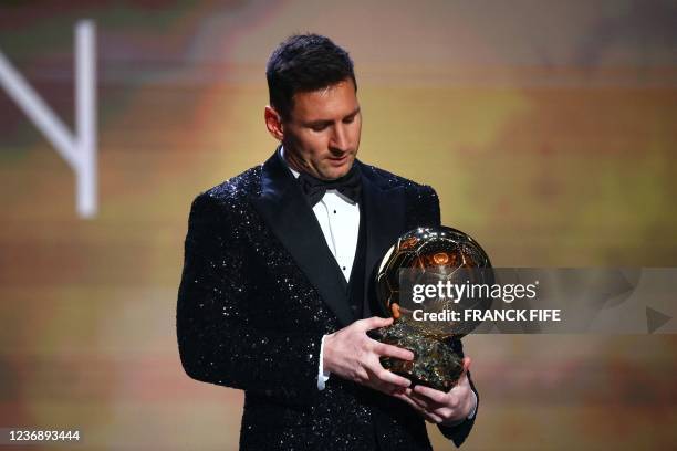 Paris Saint-Germain's Argentine forward Lionel Messi poses after being awarded the the Ballon d'Or award during the 2021 Ballon d'Or France Football...