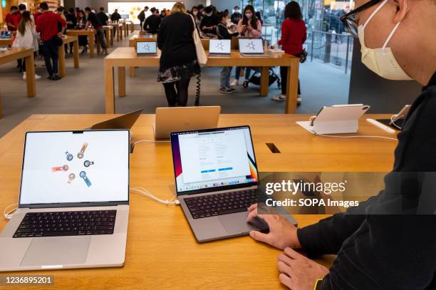 An Apple employee uses a Macbook Pro laptop with the new computer chips M1 Pro and M1 Max at an Apple store in Hong Kong.