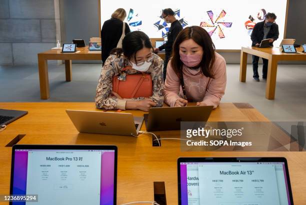 Shoppers are seen using Macbook Pro laptop with new computer chips M1 Pro and M1 Max at an Apple store in Hong Kong.