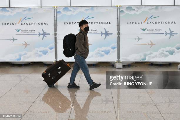 Traveller walks past a fence at Incheon International Airport on November 30 amid growing concerns about the Omicron Covid-19 variant.