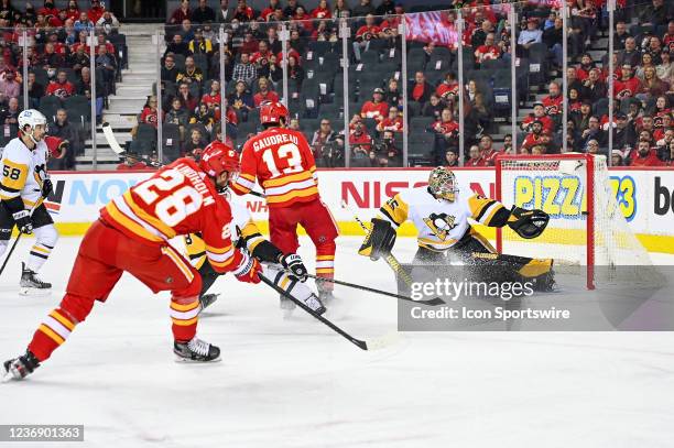 Calgary Flames Center Elias Lindholm narrowly misses the net while Pittsburgh Penguins Goalie Tristan Jarry stretches to cover his goal during the...