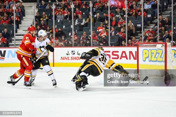 Pittsburgh Penguins Goalie Tristan Jarry stretches to try to stop a shot by Calgary Flames Center Mikael Backlund during the first period of an NHL...