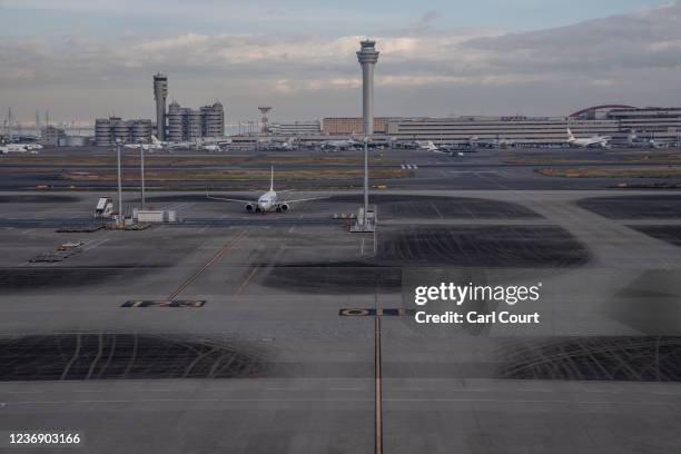 Aeroplanes sit on the tarmac at Haneda Airport on November 30, 2021 in Tokyo, Japan. Japan has imposed a ban on new entries by all foreigners for at...