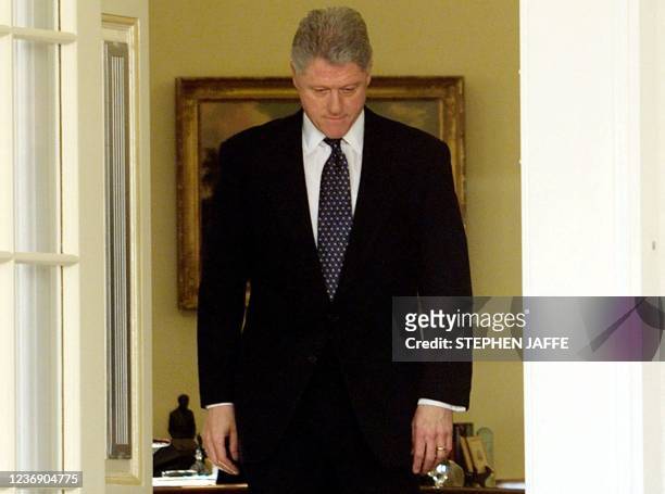 President Bill Clinton walks through the doors of the Oval Office moments before reading a statement in the Rose Garden of the White House after the...