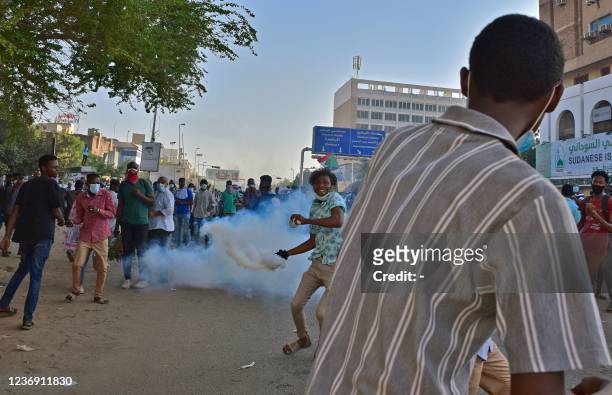 Demonstrators hurl tear gas canisters back at security forces amidst clashes in the centre of Sudan's capital Khartoum on November 30, 2021 following...