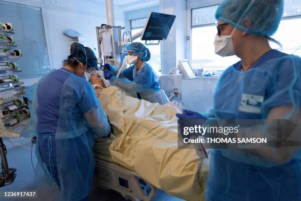 Nurses tend to a patient, infected with the Covid-19 virus, in an intensive care unit of the Pitie-Salpetriere Hospital in Paris on November 30, 2021.