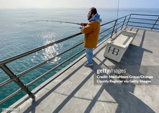 Huntington Beach, CA Albert Escobar, of Westminster, fishes off the pier in Huntington Beach, CA, on Tuesday, November 30, 2021. Anglers, who have...