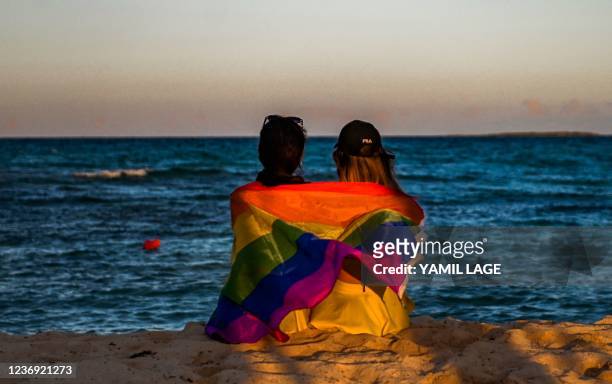 Dancers sit at the beach wrapped in a rainbow flag at the Gran Muthu Rainbow Hotel located Guillermo Key in Ciego de Avila Province, Cuba, on...
