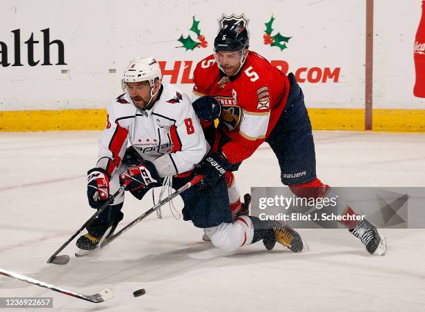 Aaron Ekblad of the Florida Panthers battles with Alex Ovechkin of the Washington Capitals at the FLA Live Arena on November 30, 2021 in Sunrise,...