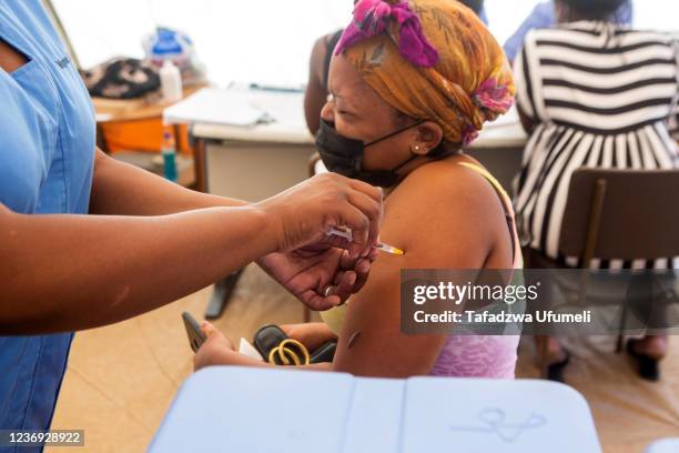 Woman reacts as she gets a Sinopharm vaccine at Parirenyatwa group of hospitals on December 01, 2021 in Harare, Zimbabwe. Zimbabwe is among the...