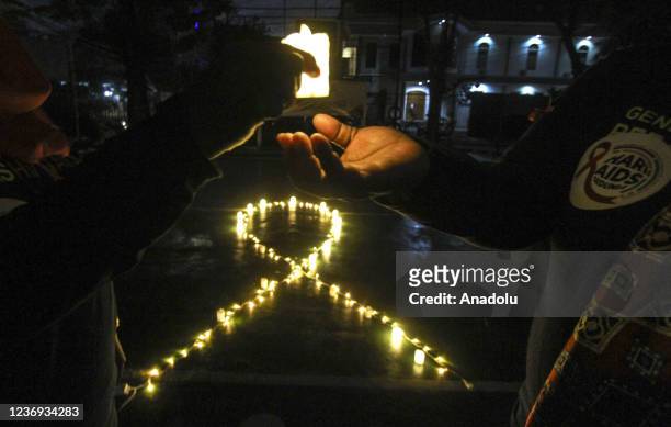 Indonesian activists hold electric candles during a vigil commemorating World AIDS day in Jakarta, Indonesia, Wednesday, Dec. 1, 2021. World AIDS Day...