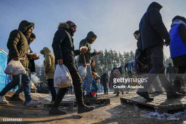 Migrants receive food as they continue to wait at a closed area at the Belarusian-Polish border in Grodno, Belarus on December 01, 2021. The migrant...