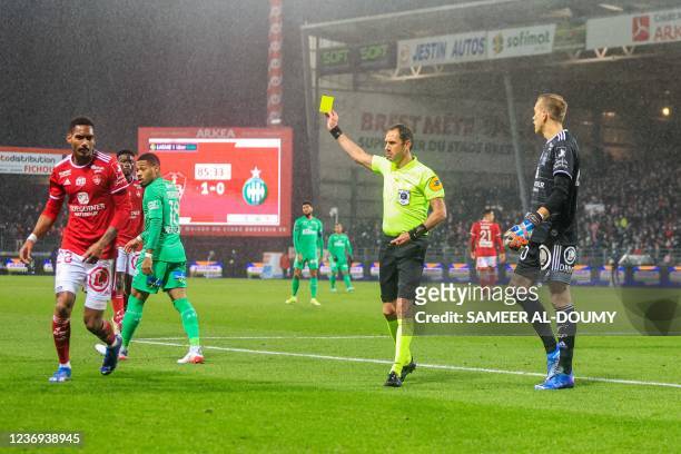French referee Mikael Lesage shows a yellow card during the French L1 football match between Stade Brestois 29 and AS Saint Etienne at Stade...