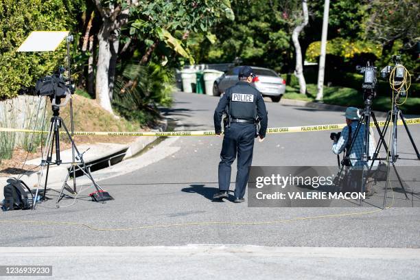 Police officer crosses under police tape as members of the media gather near the 1100 block of Maytor place where Jacqueline Avant's house is at the...