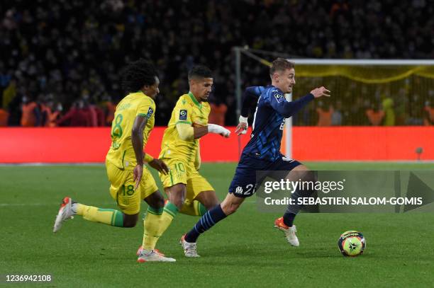 Marseille's French midfielder Valentin Rongier fights for the ball with Nantes' French midfielder Ludovic Blas and Nantes' French-Congolese...