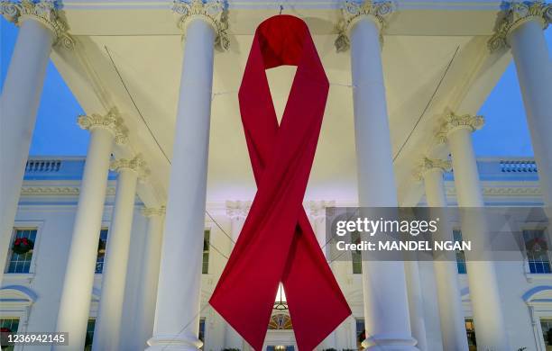 Large red ribbon is seen on the White House to mark World AIDS Day in Washington, DC on December 1, 2021.