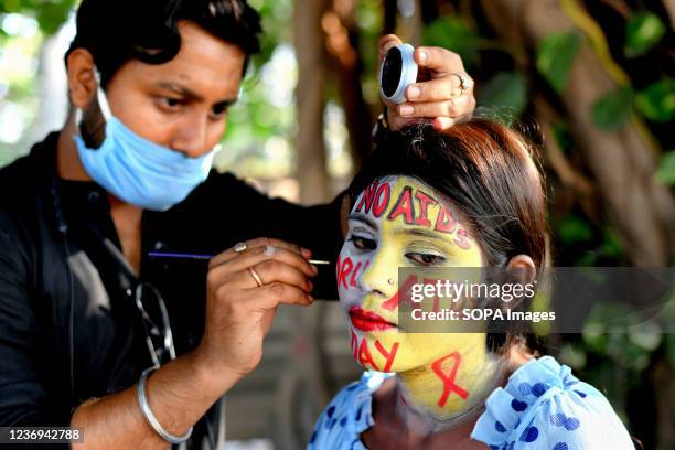 An artist seen face painting a young girl during the World AIDS Day awareness programme. World AIDS Day, celebrated annually on December 1, is an...