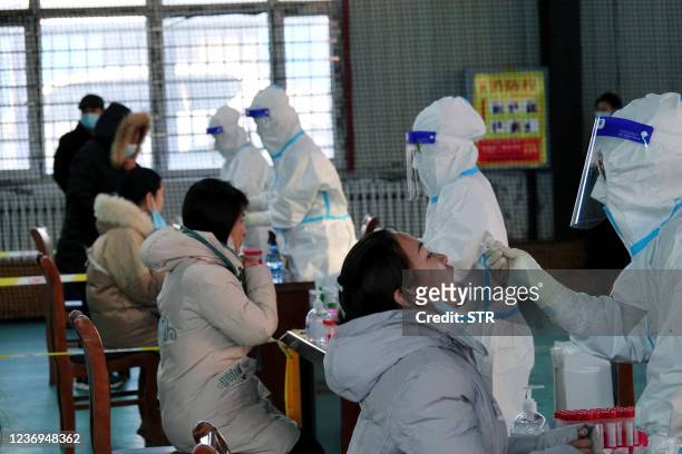 This photo taken on December 1, 2021 shows residents undergoing nucleic acid tests for the Covid-19 coronavirus in Hulun Buir, in China's Inner...