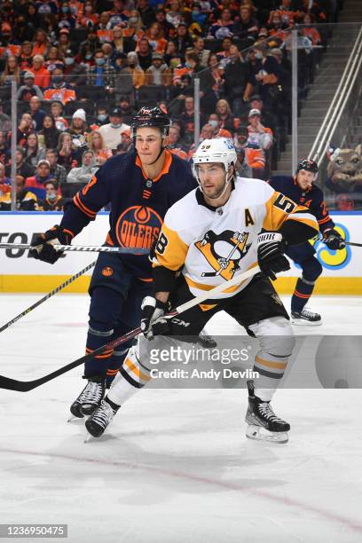 Jesse Puljujarvi of the Edmonton Oilers races for the puck against Kris Letang of the Pittsburgh Penguins on December 1, 2021 at Rogers Place in...