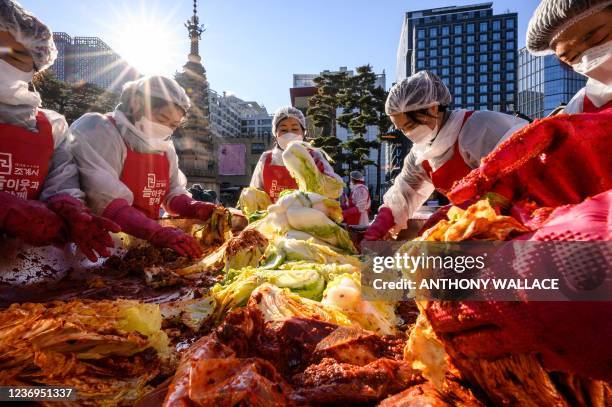 Participants prepare kimchi, a traditional Korean dish of spicy fermented cabbage and radish, during a kimchi making festival at the Jogyesa Buddhist...