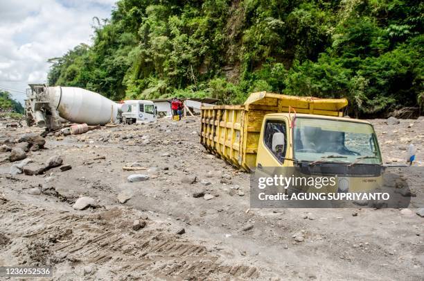 Trucks belonging to sand miners sit buried by volcanic ash after heavy rains shifted ash from the slopes of Indonesia's most active volcano, Merapi,...