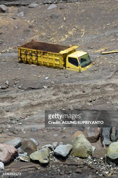 Truck belonging to sand miners sits buried by volcanic ash after heavy rains shifted ash from the slopes of Indonesia's most active volcano, Merapi,...