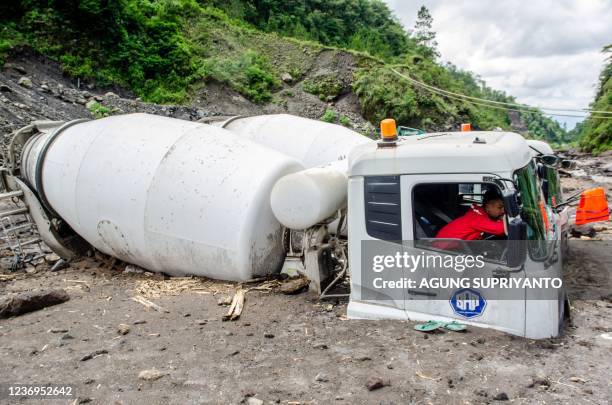 Cement trucks belonging to sand miners sit buried by volcanic ash after heavy rains shifted ash from the slopes of Indonesia's most active volcano,...