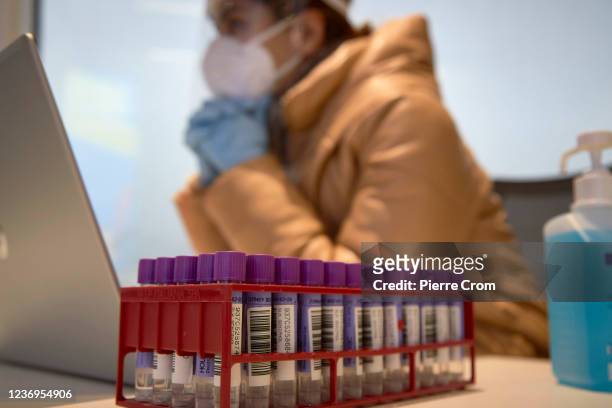 Worker of a Coronavirus testing facility waits for passengers to arrive from South Africa at Amsterdam Schiphol airport on December 2, 2021 in...