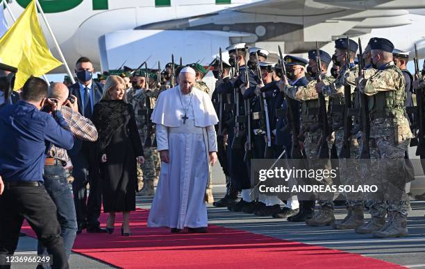 Pope Francis walks on the Red Carpet with Cypriot Parliament Speaker Annita Demetriou upon his arrival in the southern port city of Larnaca on...