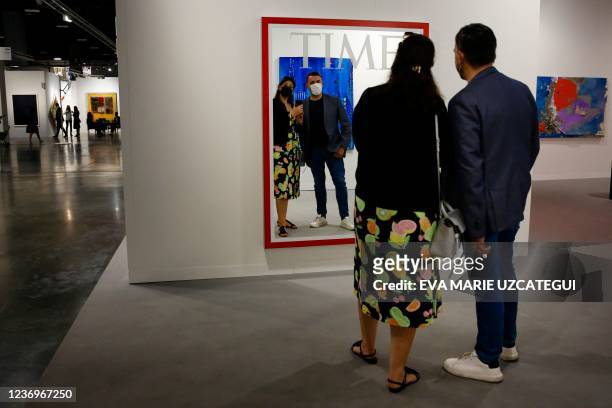 People interact with an artwork during the Art Basel 2021 at Miami Beach Convention Center in Miami Beach, Florida on December 2, 2021.