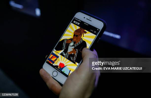 Man review NFTs artworks on his phone during Art Basel 2021 at Miami Beach Convention Center in Miami Beach, Florida, on December 2, 2021.