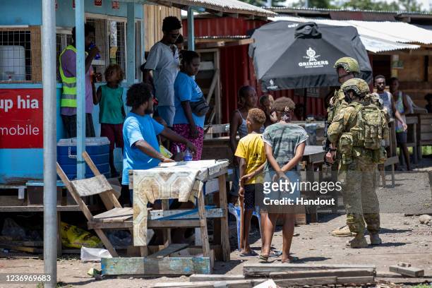 In this handout provided by the Australian Department of Defence, Australian Army soldiers from the Joint Task Group 637.3 talk with local citizens...