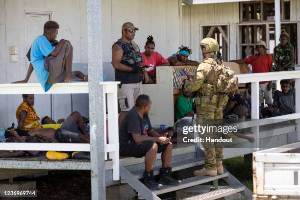 In this handout provided by the Australian Department of Defence, An Australian Army soldier from the Joint Task Group 637.3 talks with local...